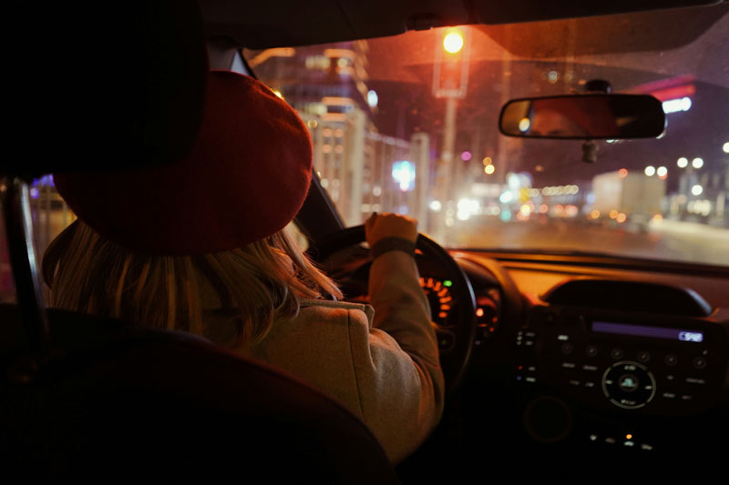 young woman driving a car at night