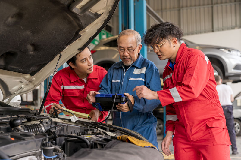 professional mechanics using a car diagnostics device